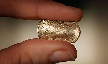fingers squashing a coin